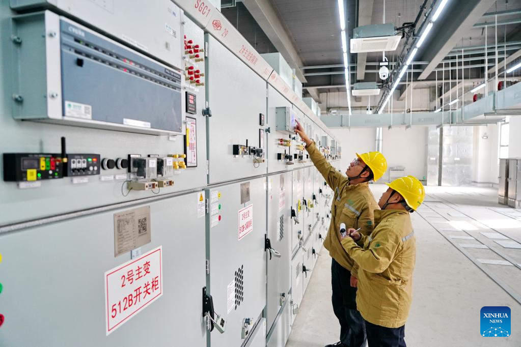 Staff members check power equipment at Wangyang substation in Xiong'an