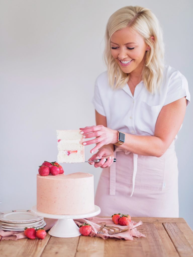 Strawberry Shortcake: Tender and fluffy layers of vanilla cake, filled with whipped cream and fresh strawberries, and covered in a strawberry buttercream. #cakebycourtney #cake #cakerecipe #strawberryshortcake #shortcake #strawberry #buttercream