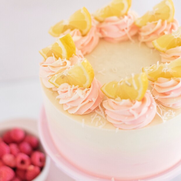 Coconut Lemon Raspberry Cake - coconut cake layers, lemon curd, raspberry cream filling, and coconut buttercream. #cakebycourtney #coconutcake #bestcoconutcake #lemoncurd #raspberrycream #raspberryfilling #coconutbuttercream #summercake #bestsummerdessertrecipes #summercakes #summerdessertrecipes