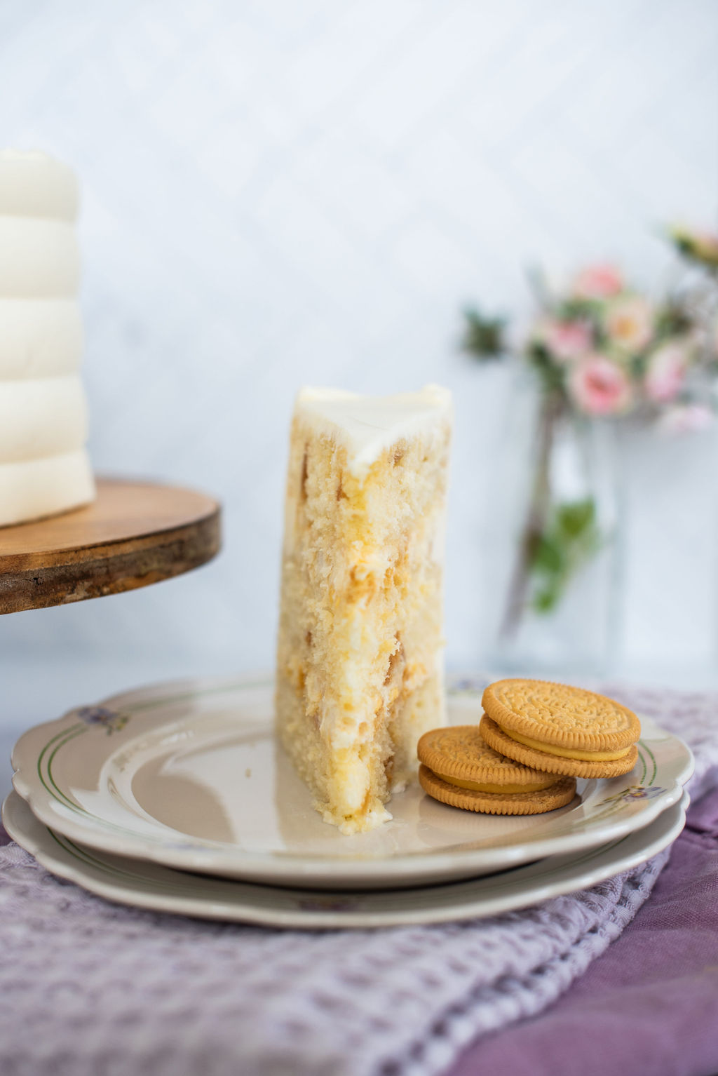 A slice of cake on a plate with cookies.