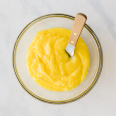 Lemon curd in a glass bowl.