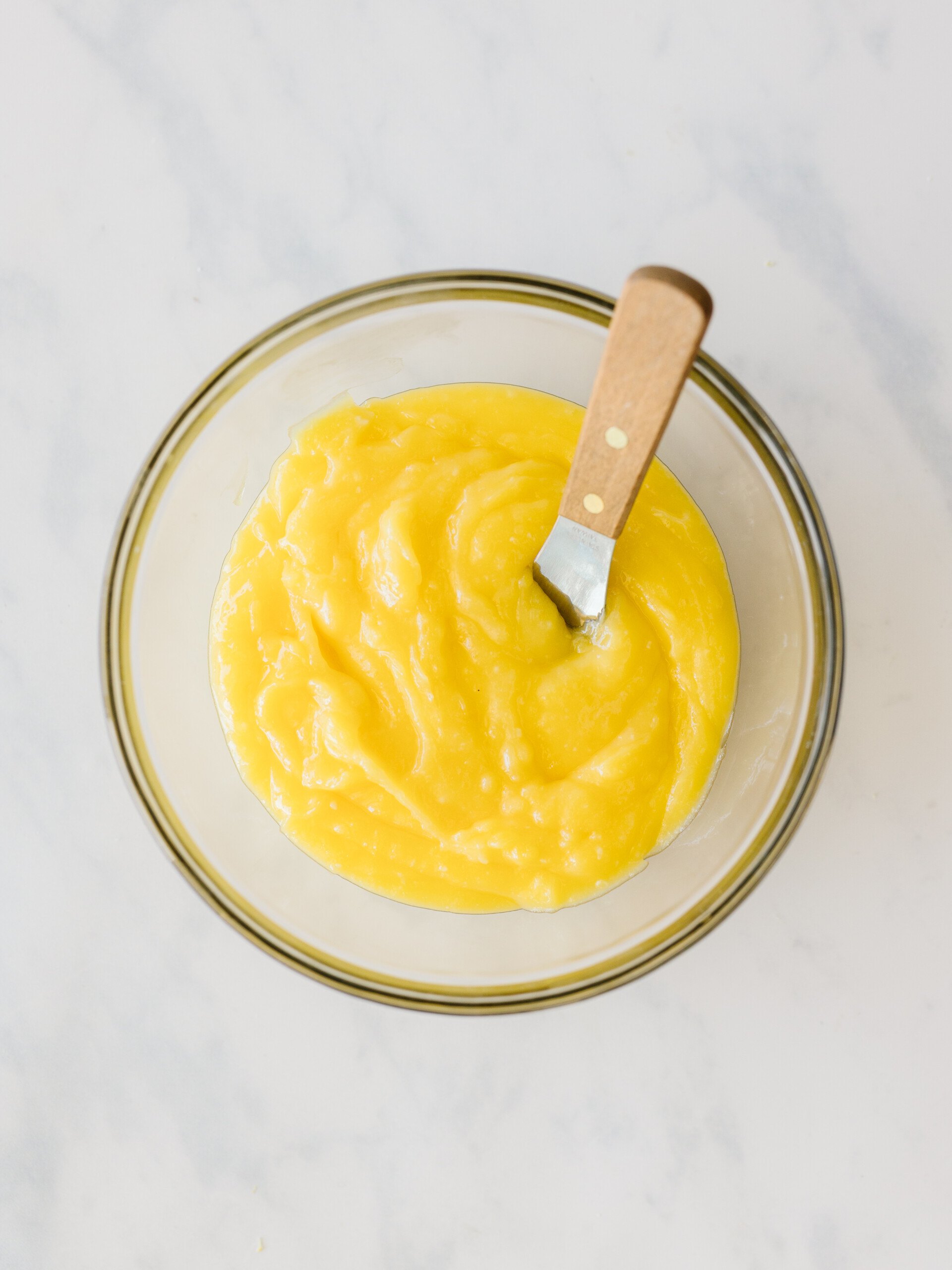 Lemon curd in a glass bowl.