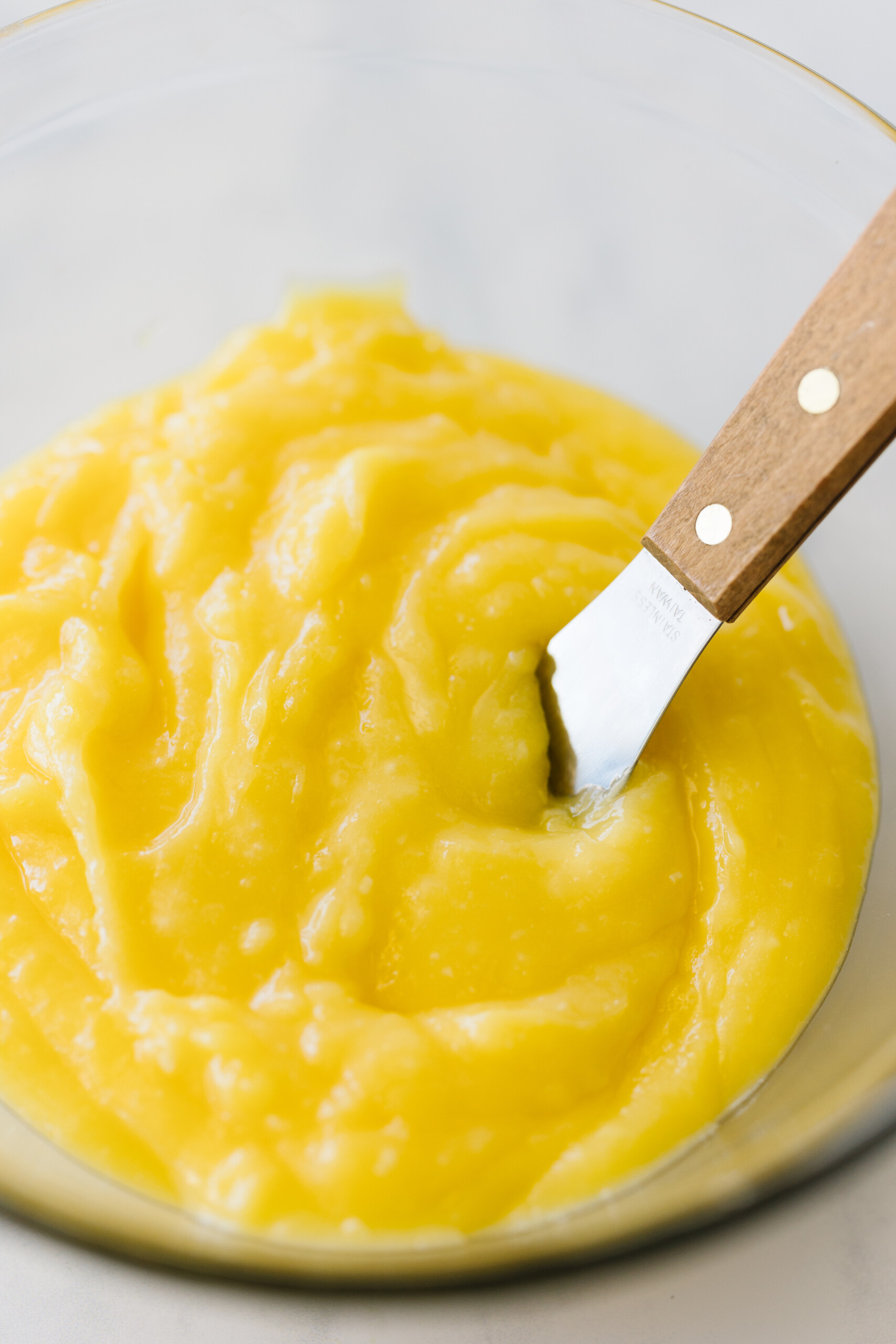 Lemon curd in a glass bowl.