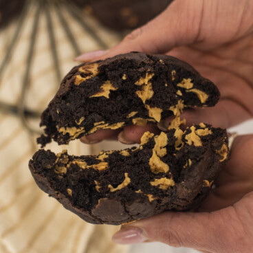 Hands holding a cookie split in half.