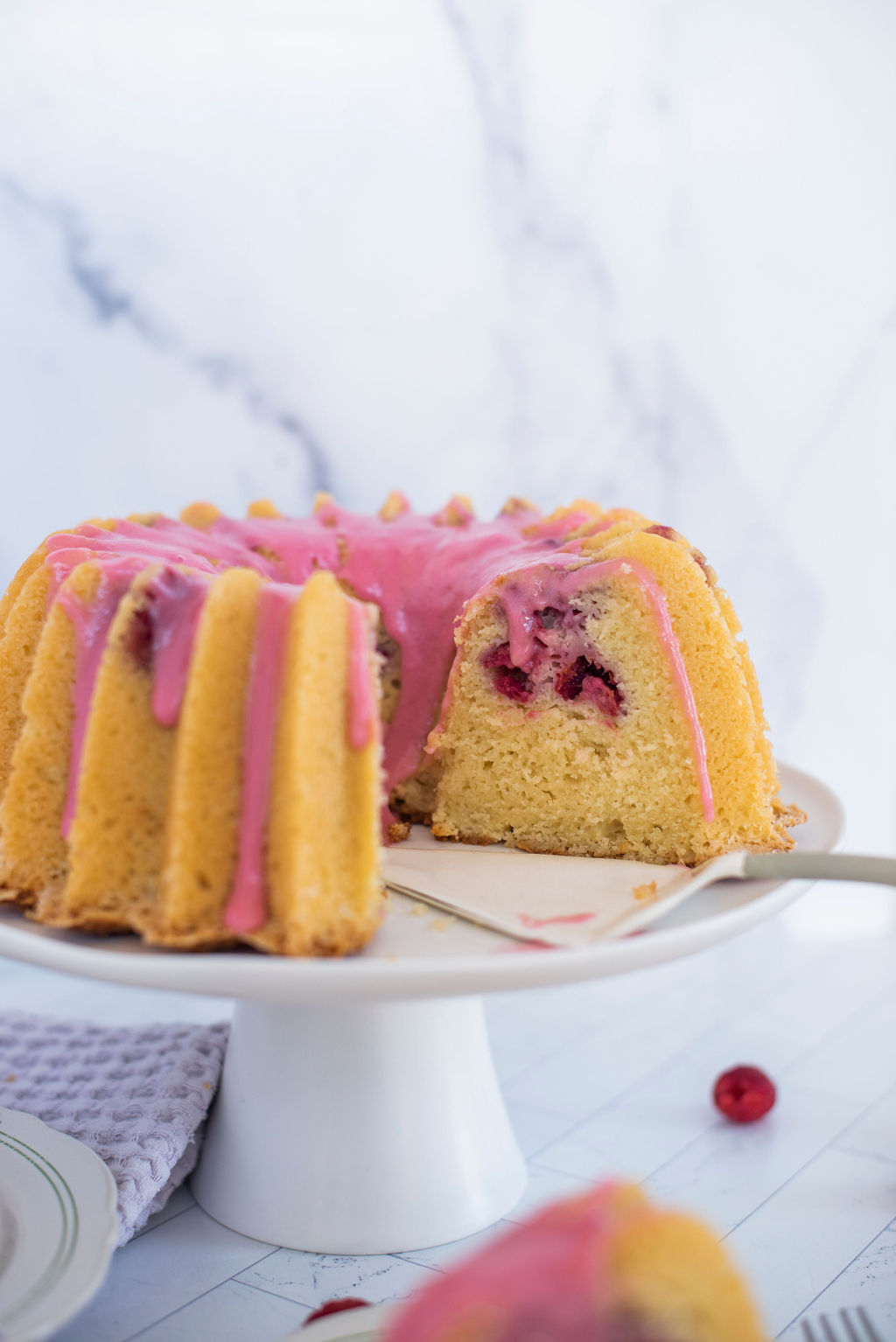 A cut bundt cake on a cake stand.