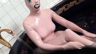 Tanja takes a bath in her latex sex doll costume